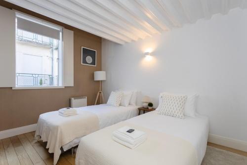 zwei Betten in einem Zimmer mit Fenster in der Unterkunft Local 167 - Oporto View House in Vila Nova de Gaia