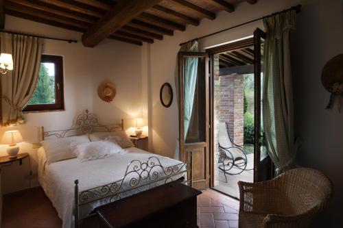 a bedroom with a bed and a sliding glass door at Il Torrino Country Resort in Montaione