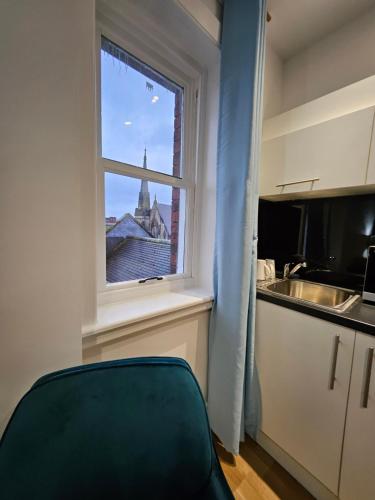 a kitchen with a window with a view of a church at Central Chambers Suites - Suite 4 in Leek