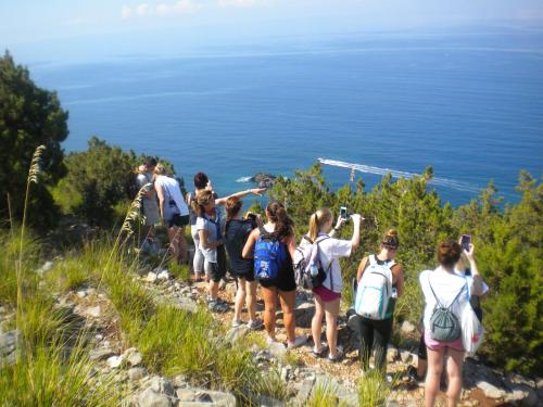 a group of people standing on a hill looking at the ocean at Bed & Breakfast Spigolatrice in Sapri