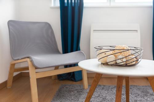 una silla y una mesa con un tazón de aperitivos. en My Colmar Homes - Colmar Rempart, en Colmar