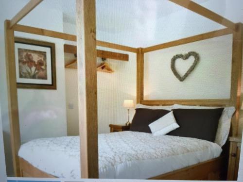 a bedroom with a four poster bed with a heart on the wall at Shrewsbury Cottage in Shrewsbury