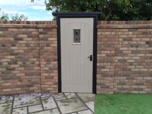 a white door in a brick wall at Shrewsbury Cottage in Shrewsbury