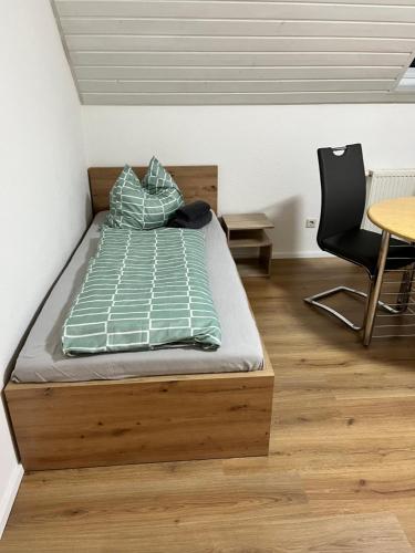 a bed in a room with a table and a chair at Gästehaus Wettemann in Lauchheim