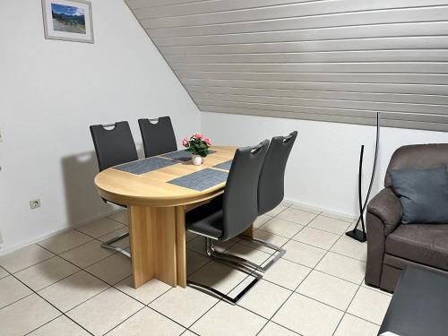 a dining room with a wooden table and chairs at Gästehaus Wettemann in Lauchheim