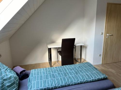 a bedroom with a bed and a desk and a chair at Gästehaus Wettemann in Lauchheim