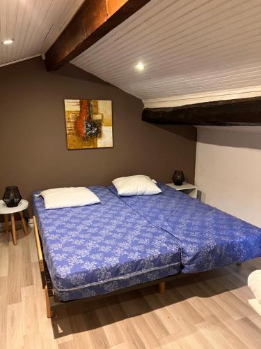 une chambre avec un lit avec une couette bleue dans l'établissement Côté de jissiere, à Sumène