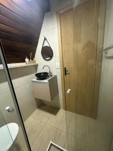 a bathroom with a sink and a shower at Chale Bombinhas Porto Belo in Porto Belo