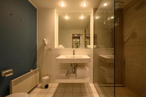 a bathroom with a sink and a mirror at Hotel Watermolen Le Mirage in Kasterlee