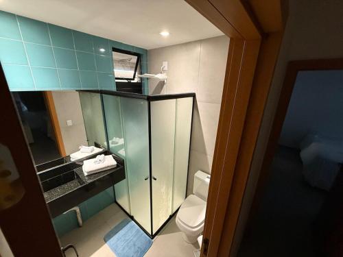 baño con aseo y armario de cristal en Lindo Apartamento em Cotovelo, en Parnamirim