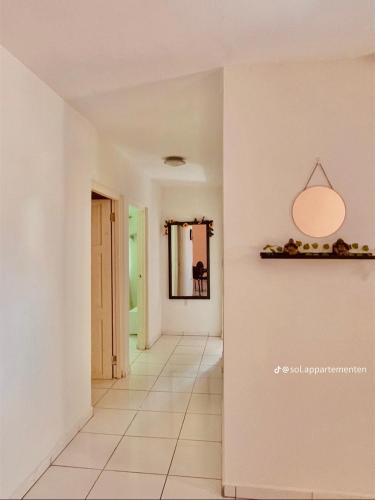 a hallway with a white floor and a light fixture at Sol Vakantie Appartementen Curaçao in Willemstad