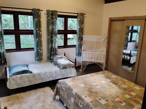 a bedroom with two beds and a window at Mansão Adonai nas Cachoeiras de Penedo in Penedo