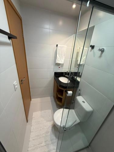 a white bathroom with a toilet and a sink at Apartamento Amplo e Confortável em Condomínio Familiar, 3 Quartos Sendo 1 Suíte com Lazer de Clube in Belém
