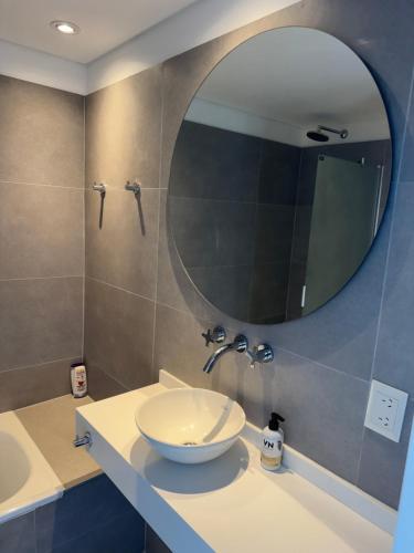 a bathroom with a sink and a mirror at Edificio Libertador , Ushuaia in Ushuaia