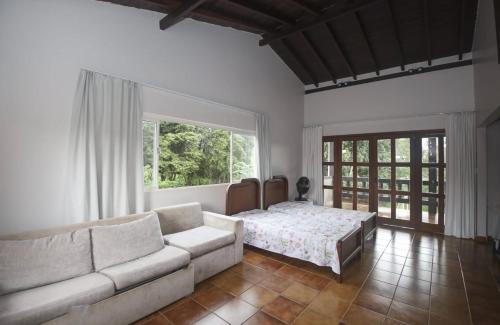 a living room with a couch and a bed at Villa Verde casa espaçosa com piscina e área verde no Lago Norte Brasilia in Brasília