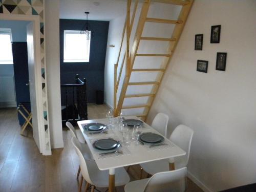 une salle à manger avec une table blanche et des chaises blanches dans l'établissement Apartment Lille - Proche métro - Stationnement gratuit, à Lille
