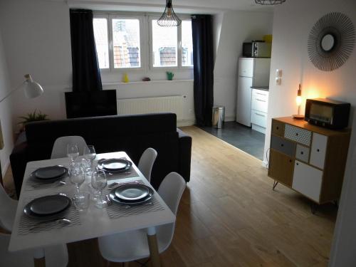 un salon avec une table et des chaises et une cuisine dans l'établissement Apartment Lille - Proche métro - Stationnement gratuit, à Lille