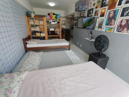 a dorm room with two beds and a fan at Melhor localização Recife até 6 pessoas in Recife