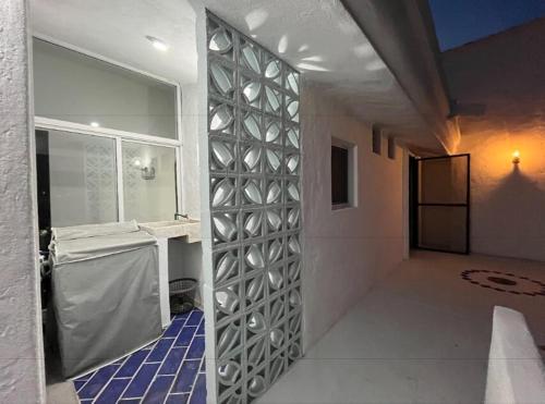 a bathroom with a wall with a mirror at Penthouse en Manzanillo a Pie de Playa in Manzanillo