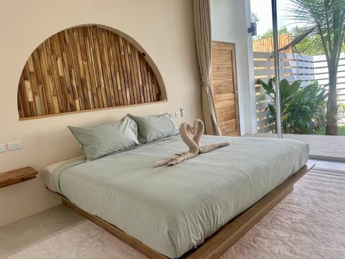 a bed with a stuffed animal sitting on top of it at Oh'lala Two Bedroom Pool Villas in Koh Phangan