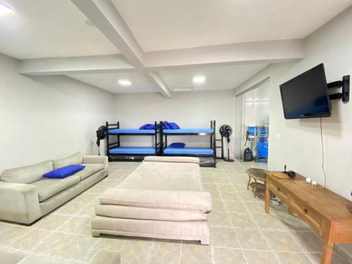 a living room with two bunk beds and a flat screen tv at Casa Pazim in Itanhaém