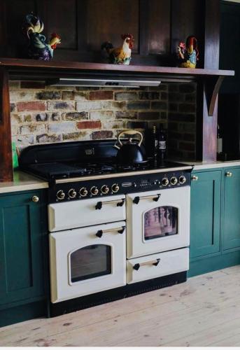 a kitchen with a stove and a brick wall at Galway Cottage ADL Retaining Pty Ltd trading as Murphys Coittages in Willunga