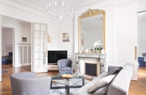 un salon avec un canapé et un miroir dans l'établissement Appartement Haussmannien Saint Michel Notre Dame, à Paris