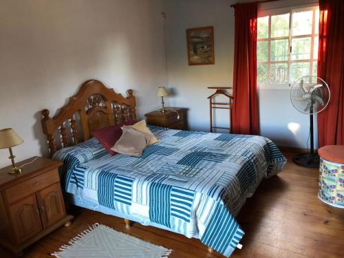 a bedroom with a bed with a blue and white comforter at Casas de alquiler FIKA in Capilla del Monte