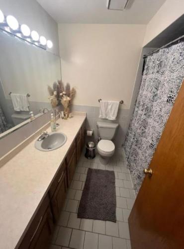 a bathroom with a sink and a toilet and a mirror at 3BR-2BA Deluxe Apartment with Fireplace and Balcony in Niles