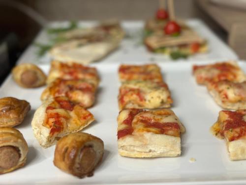 a tray filled with different types of pizza and rolls at Ines Apartments in Giardini Naxos