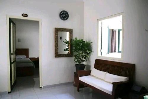 ein Wohnzimmer mit einer Bank und einem Spiegel in der Unterkunft Ndalem Kadipaten Homestay in Ngabean