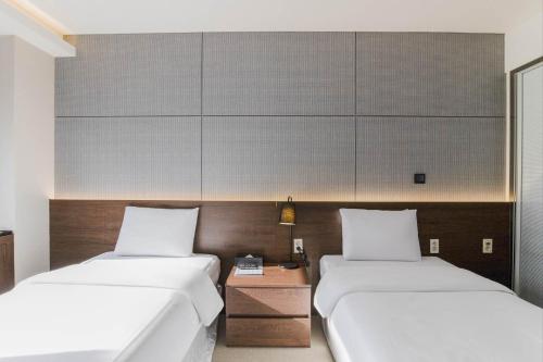 two beds in a room with two beds sidx sidx sidx at Hotel Elora in Suwon