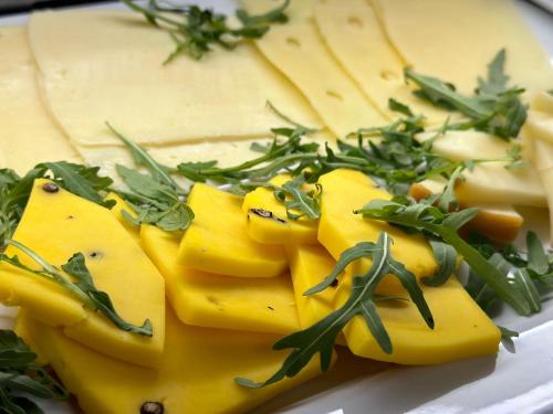 a plate of cheese with greens on top of it at Ines Apartments in Giardini Naxos
