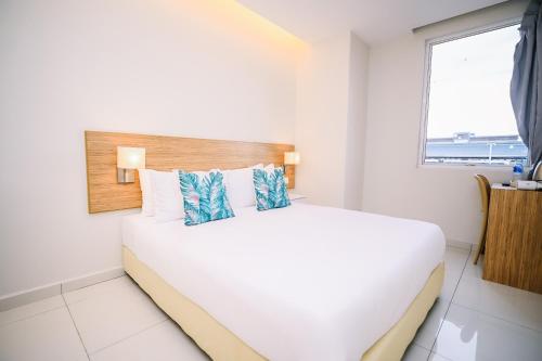 a white bedroom with a large bed with a window at Swing & Pillows - Kelana Jaya Selangor in Petaling Jaya