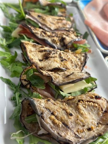a white plate with four sandwiches on a salad at Ines Apartments in Giardini Naxos