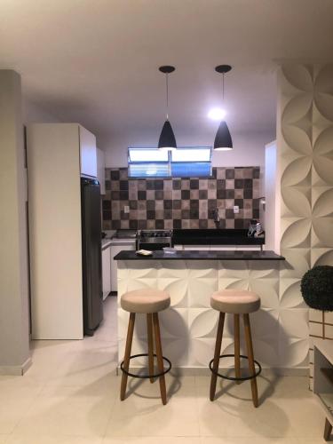 a kitchen with two stools and a counter top at Apartamento na Praia do Guaibim in Ponta da Areia