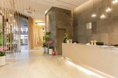 a lobby with a counter and potted plants at Hotel Elora in Suwon
