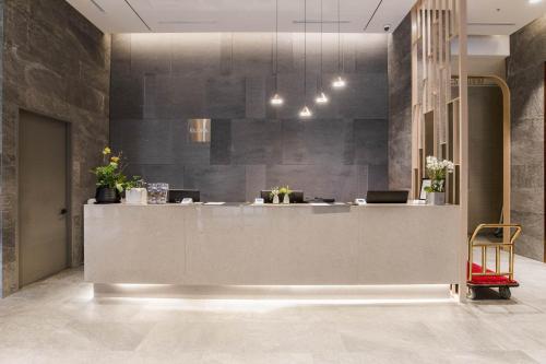 a lobby with a reception desk in a building at Hotel Elora in Suwon