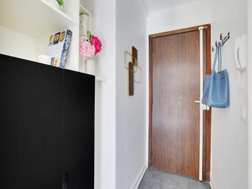 a room with a wooden door and a black cabinet at Studio near Bassin de la Villette - 2P balcony in Paris