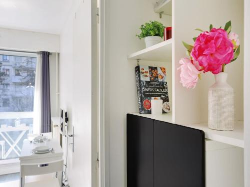 a living room with a tv and a flower on a shelf at Studio near Bassin de la Villette - 2P balcony in Paris