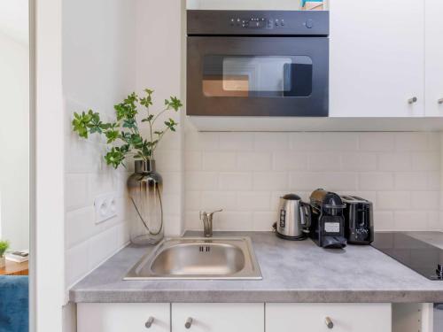 a kitchen counter with a sink and a microwave at Charming studio for 2 people - Mobility lease in Paris