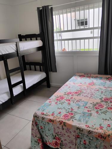 a bedroom with a bed and a bunk bed and a window at Casa e conforto in Itapoa