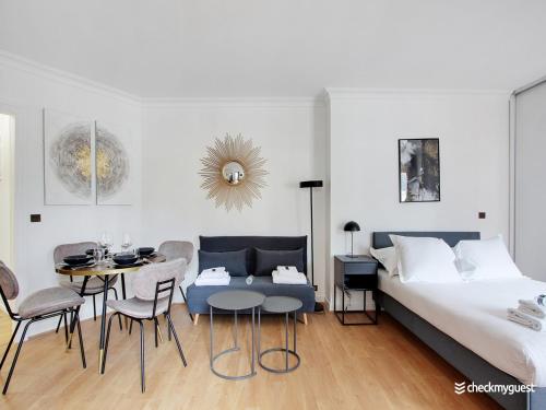a bedroom with a bed and a table and chairs at Quiet and bright studio - 2P - Rueil Malmaison in Rueil-Malmaison