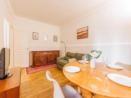 un salon avec une table et un canapé dans l'établissement Charmant appt - 1 BDR 2P convention 15e arr, à Paris