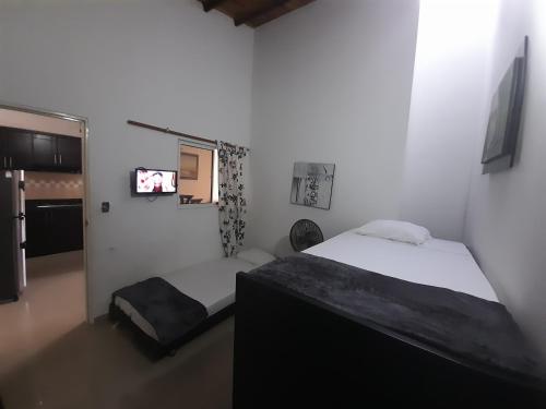 a bedroom with two beds and a tv in it at APARTAMENTO DE LUJO SAN GIl in San Gil