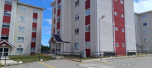 dos edificios altos con lados rojos y blancos en Departamento Balneario Pelluco, en Puerto Montt