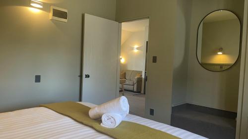 a bedroom with a bed and a large mirror at The Elmwood Motel in Christchurch