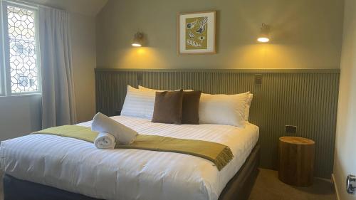 a bedroom with a large bed with white sheets at The Elmwood Motel in Christchurch