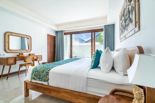 a bedroom with a bed and a desk and a window at Akasia Hill Villas in Nusa Dua