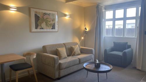 a living room with a couch and a chair at The Elmwood Motel in Christchurch
